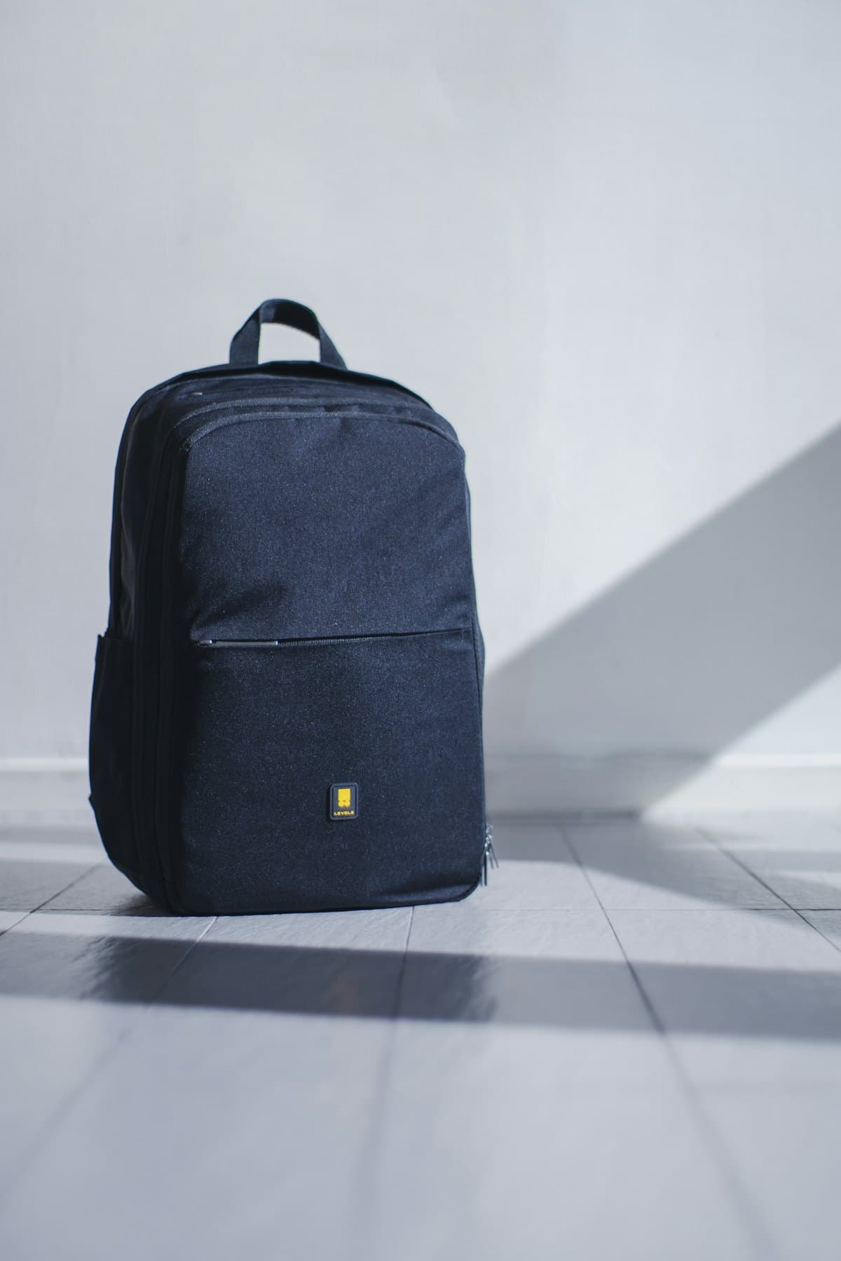 Navy backpack on a light grey backdrop