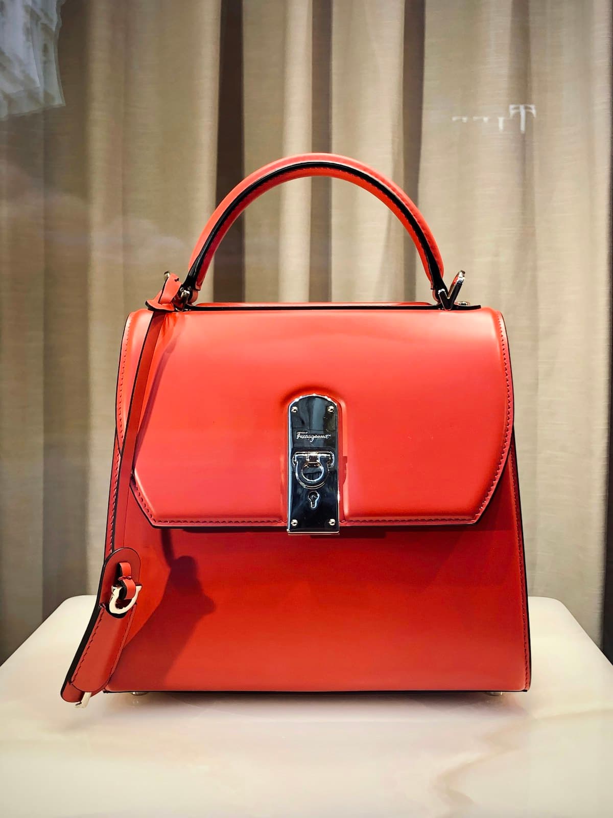Red leather handbag on a studio backdrop